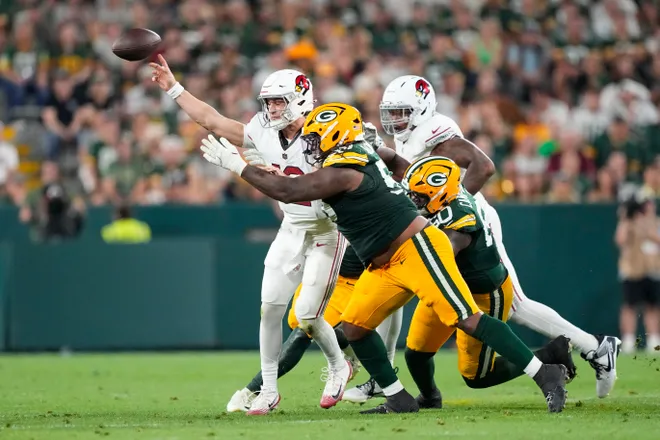Aug 28, 2026; Green Bay, Wisconsin, USA;  Arizona Cardinals quarterback Kedon Slovis (12) throws a pass under pressure from Green Bay Packers defensive tackle Chris McClellan (55) during the second quarter at Lambeau Field. Mandatory Credit: Jeff Hanisch-Imagn Images