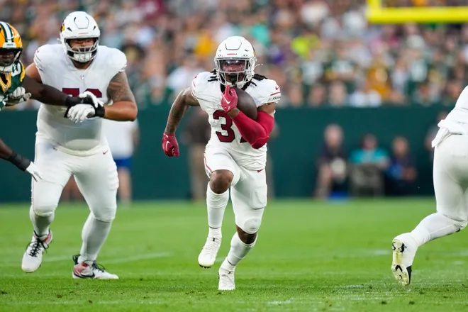 Aug 28, 2026; Green Bay, Wisconsin, USA;  Arizona Cardinals running back Corey Kiner (37) rushes with the football during the first quarter against the Green Bay Packers at Lambeau Field. Mandatory Credit: Jeff Hanisch-Imagn Images