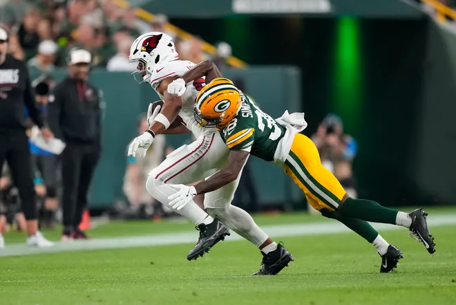 Aug 28, 2026; Green Bay, Wisconsin, USA;  Arizona Cardinals tight end Elijah Higgins (84) rushes with the football after catching a pass in front of Green Bay Packers cornerback Jaylin Simpson (38) during the second quarter at Lambeau Field. Mandatory Credit: Jeff Hanisch-Imagn Images