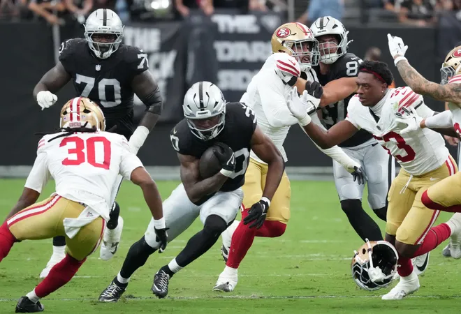 Aug 27, 2026; Paradise, Nevada, USA; Las Vegas Raiders running back Mike Washington Jr. (30) runs the ball against San Francisco 49ers linebacker Jaden Dugger (53) and cornerback Eli Apple (30) during the first quarter at Allegiant Stadium. Mandatory Credit: Kirby Lee-Imagn Images