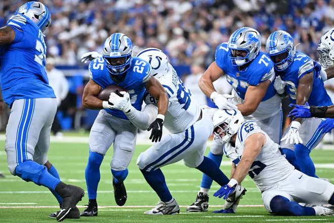 Aug 29, 2026; Indianapolis, Indiana, USA;  Detroit Lions running back Jacob Saylors (25) runs with the ball against Indianapolis Colts defensive tackle Adetomiwa Adebawore (95) during the first half at Lucas Oil Stadium.  Mandatory Credit: Robert Goddin-Imagn Images