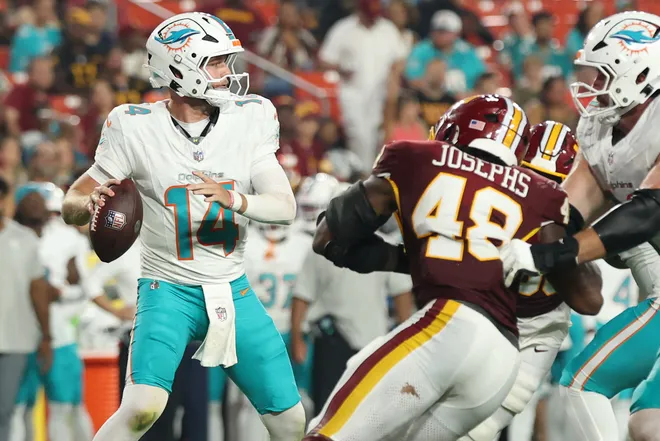Aug 14, 2026; Landover, Maryland, USA; Miami Dolphins quarterback Quinn Ewers (14) passes the ball as Washington Commanders linebacker Joshua Josephs (48) rushes during the first half at Northwest Stadium. Mandatory Credit: Geoff Burke-Imagn Images
