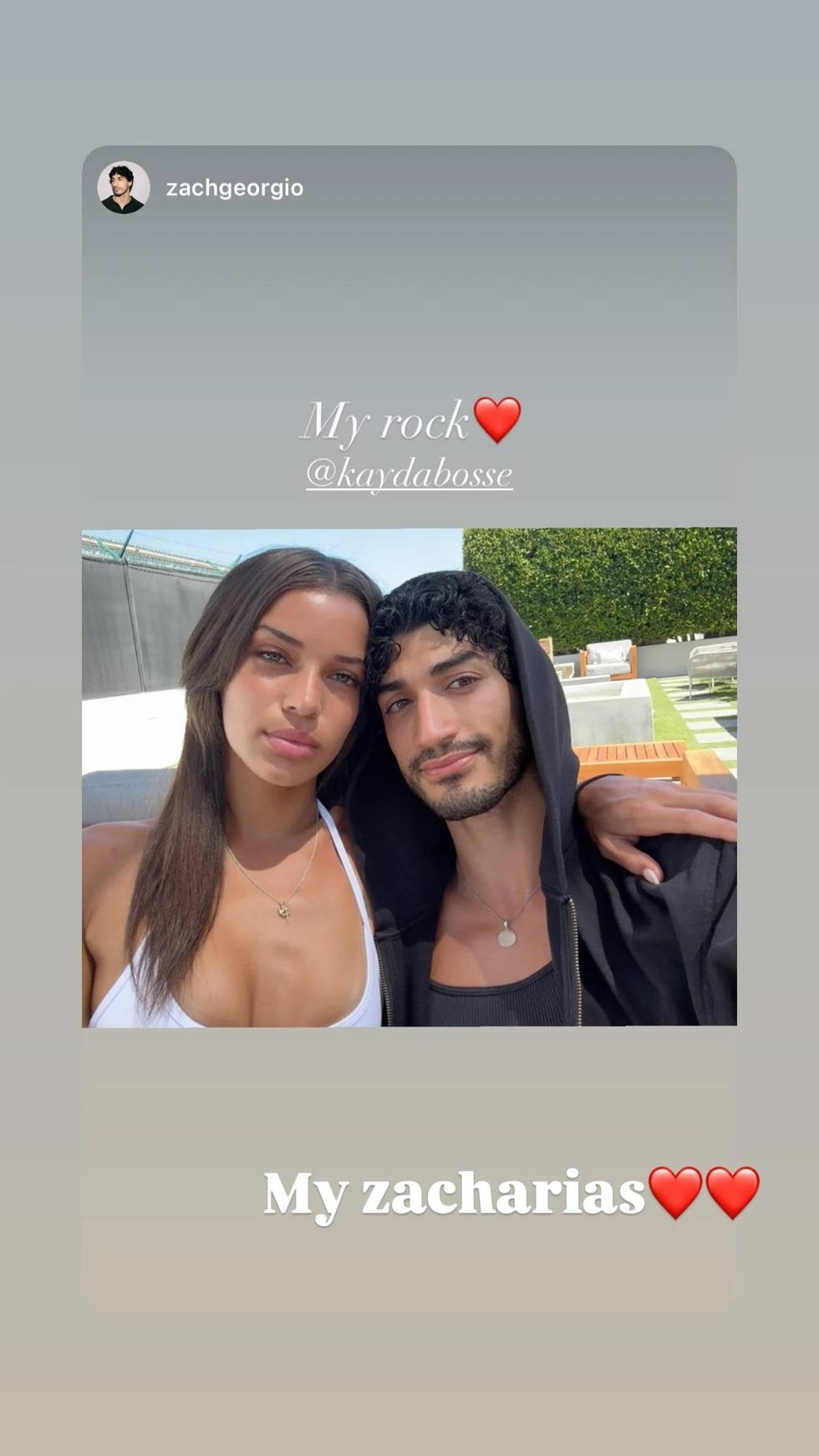 A young couple posing together outdoors, expressing affection in a social media post.