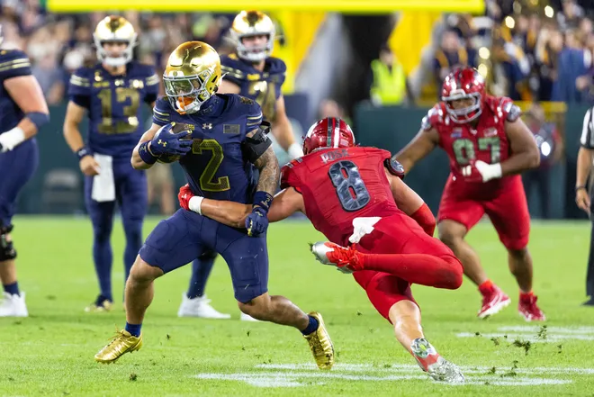 Sep 6, 2026; Green Bay, Wisconsin, USA;  Notre Dame Fighting Irish running back Nolan James Jr. (2) rushes teh ball past Wisconsin Badgers linebacker Mason Posa (8) at Lambeau Field.  Mandatory Credit: Trevor Ruszkowski-Imagn Images