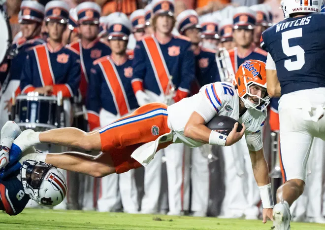 Florida Gators quarterback Aaron Philo (12) is tripped up by Auburn Tigers safety Kaleb Harris (8) as Auburn Tigers take on Florida Gators at Jordan-Hare Stadium in Auburn, Ala. on Saturday, Sept. 19, 2026. Florida Gators lead Auburn Tigers 20-17 at halftime.