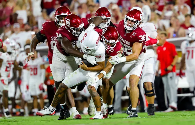 Sep 19, 2026; Norman, Oklahoma, USA; Oklahoma Sooners defensive lineman Adepoju Adebawore (34) and Oklahoma Sooners defensive back Peyton Bowen (22) tackle New Mexico Lobos quarterback Toa Fa'avae (13) during the second half at Gaylord Family-Oklahoma Memorial Stadium. Mandatory Credit: Kevin Jairaj-Imagn Images