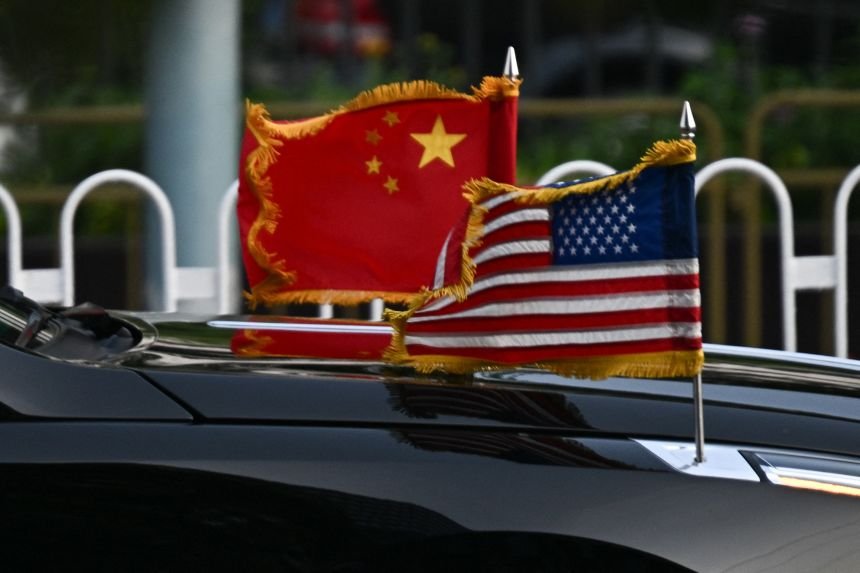 The US and China flags are seen on a vehicle in the motorcade of US President Donald Trump as it leaves the hotel in Beijing on May 14, 2026.