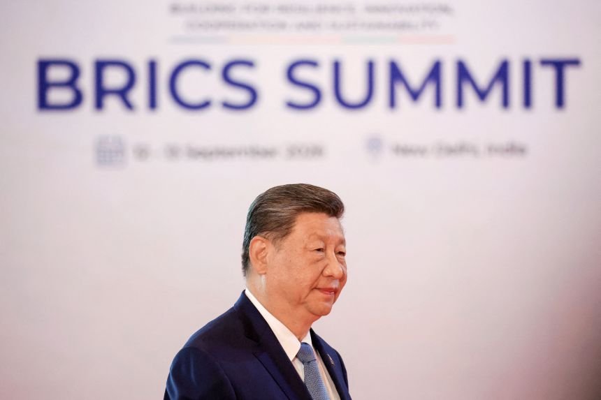 In this pool photograph distributed by the Russian state agency Sputnik, China's President Xi Jinping arrives before the start of the 18th BRICS Summit in New Delhi on September 12, 2026.