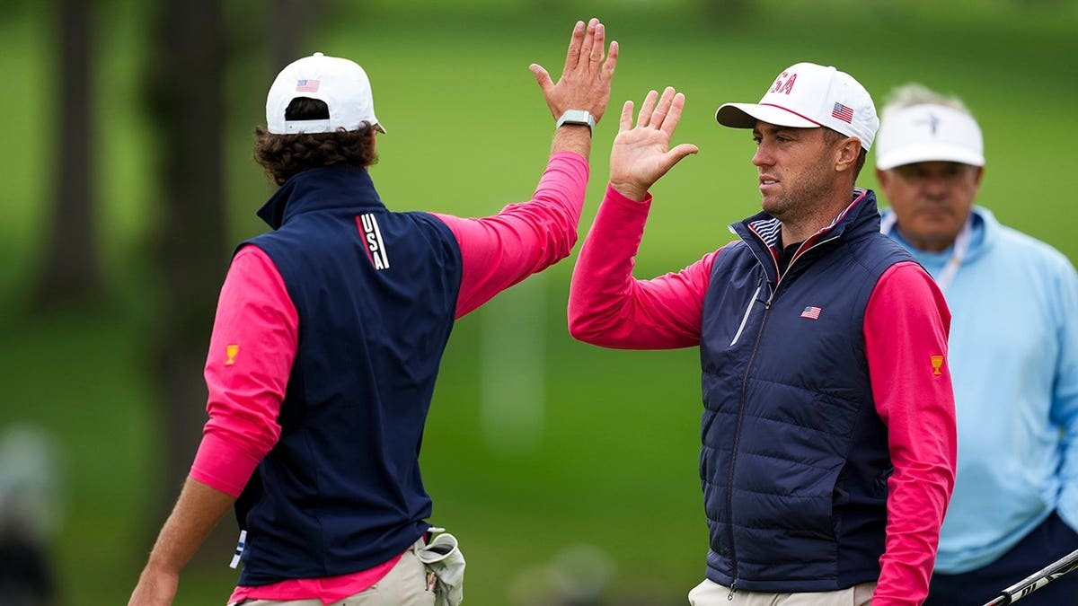 Justin Thomas high-fives Jackson Koivun before the Presidents Cup in Medinah, Illinois.