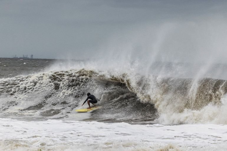 A surfer catches a wave as a nor'easter batters the US northeast coast, in Rockaway, New Jersey, US, September 26, 2026. REUTERS/Caitlin Ochs