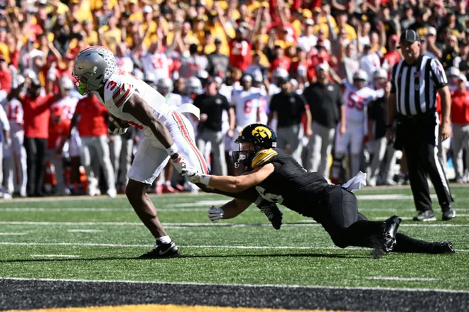 Oct 3, 2026; Iowa City, Iowa, USA;  Ohio State Buckeyes wide receiver Devin McCuin (3) runs to score a touchdown against Iowa Hawkeyes defensive back Zach Lutmer (6) during the first half at Kinnick Stadium.  Mandatory Credit: Jeffrey Becker-Imagn Images