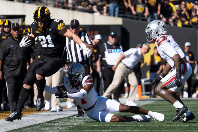 Iowa Hawkeyes tight end DJ Vonnahme (81) tries to evade a tackle by Ohio State Buckeyes cornerback Jermaine Mathews Jr. (7) at Kinnick Stadium in Iowa City, Iowa, on Oct. 3, 2026.