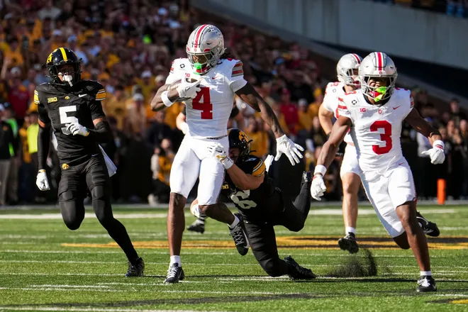 Ohio State Buckeyes wide receiver Jeremiah Smith (4) runs for a first down as Iowa Hawkeyes defensive back Zach Lutmer (6) attempts a tackle during the NCAA football game at Kinnick Stadium in Iowa City on Oct. 3, 2026.