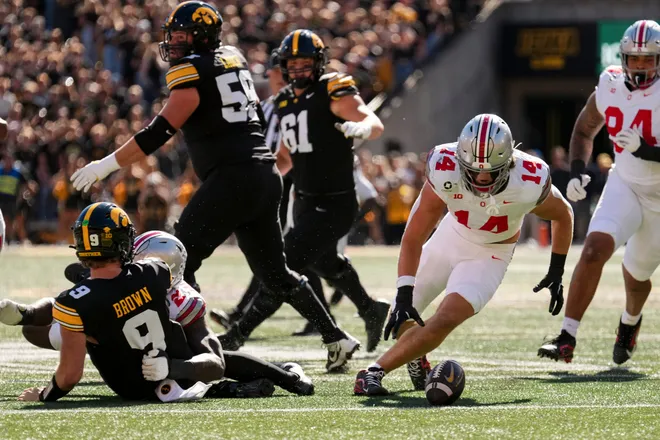 Ohio State Buckeyes linebacker Christian Alliegro (14) scoops up a fumble after defensive end Kenyatta Jackson Jr. (2) sacks Iowa Hawkeyes quarterback Hank Brown (9) during the NCAA football game at Kinnick Stadium in Iowa City on Oct. 3, 2026.