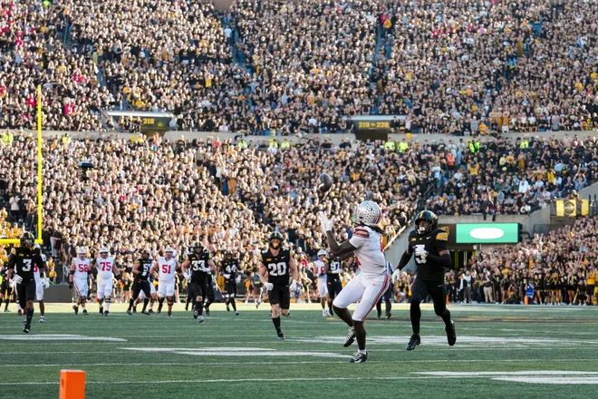 Ohio State Buckeyes wide receiver Jeremiah Smith (4) catches a touchdown pass, breaking the school's all-time record, behind Iowa Hawkeyes defensive back Anthony Hawkins (5) during the NCAA football game against the Iowa Hawkeyes at Kinnick Stadium in Iowa City on Oct. 3, 2026. Ohio State on 31-14.