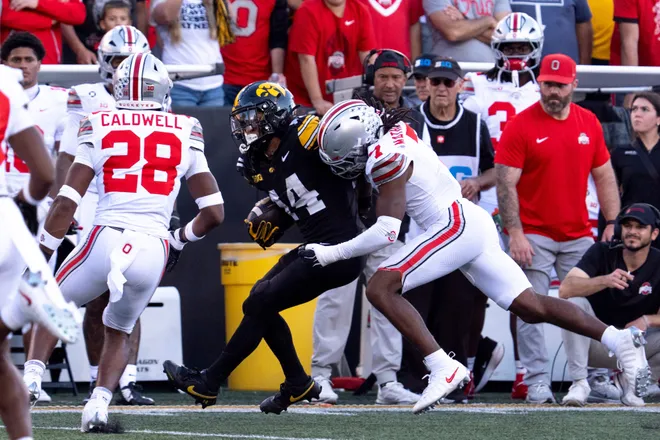Iowa Hawkeyes wide receiver Tony Diaz (14) is tackled by Ohio State Buckeyes cornerback Jermaine Mathews Jr. (7) during a Big Ten college football game Oct. 3, 2026 at Kinnick Stadium in Iowa City, Iowa.