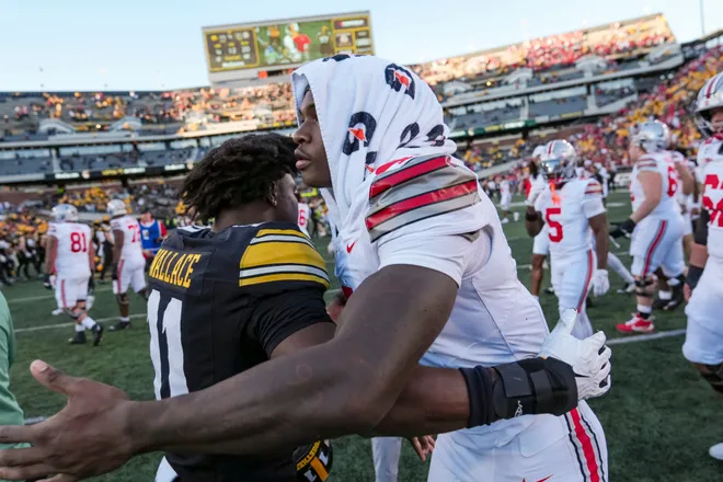 Ohio State Buckeyes wide receiver Jeremiah Smith (4) hugs Iowa Hawkeyes defensive back Jacob Wallace (11)  the NCAA football game at Kinnick Stadium in Iowa City on Oct. 3, 2026.