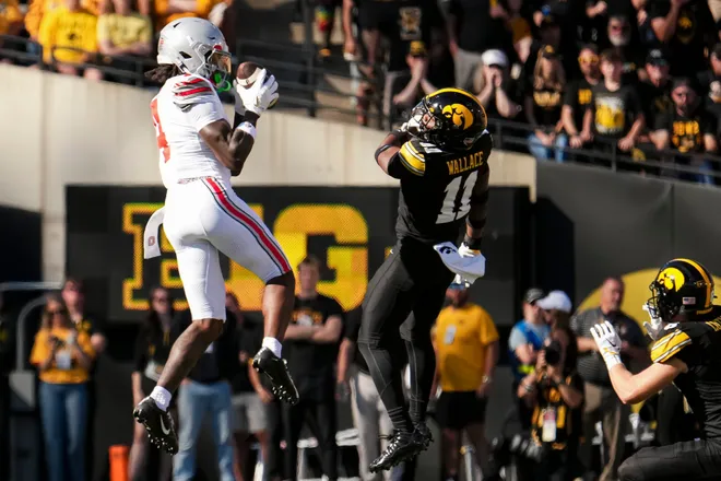Ohio State Buckeyes wide receiver Jeremiah Smith (4) catches a pass in front of Iowa Hawkeyes defensive back Jacob Wallace (11) during the NCAA football game at Kinnick Stadium in Iowa City on Oct. 3, 2026.