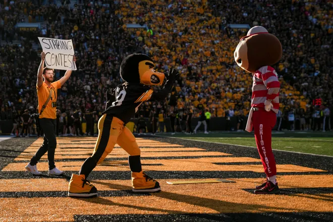 Ohio State Buckeyes mascot Brutus Buckeye has a staring contest with Iowa Hawkeyes mascot Herky during the NCAA football game at Kinnick Stadium in Iowa City on Oct. 3, 2026.