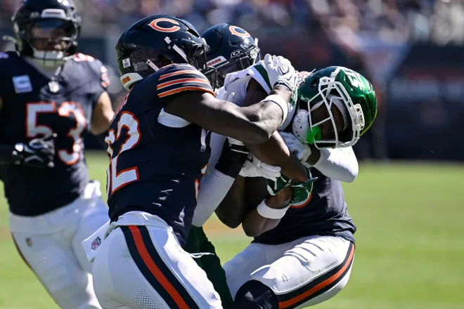 Oct 4, 2026; Chicago, Illinois, USA;  Chicago Bears safety Xavier Woods (32) and defensive back Tyrique Stevenson (29) tackle New York Jets wide receiver Isaiah Williams (18) during the second quarter at Soldier Field.  Mandatory Credit: Matt Marton-Imagn Images
