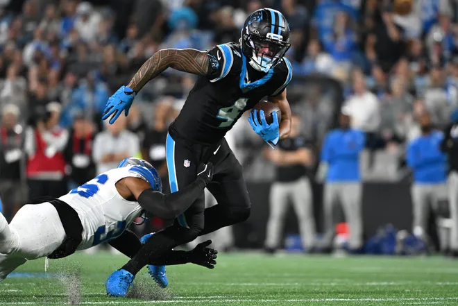 Oct 4, 2026; Charlotte, North Carolina, USA;  Carolina Panthers wide receiver Tetairoa McMillan (4) carries the ball after a reception defended by Detroit Lions safety Chuck Clark (36) during the fourth quarter at Bank of America Stadium.  Mandatory Credit: Bob Donnan-Imagn Images